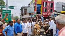 Protest against inflation by placing gas cylinder on bullock cart, sloganeering