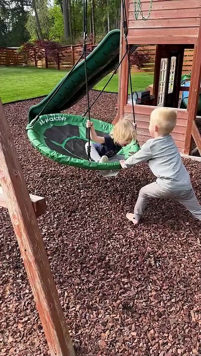 Siblings Play on Swing Set