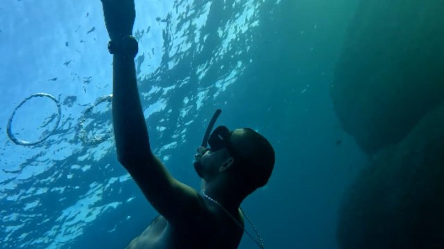 Freediver effortlessly breathes out delicate bubble rings *Underwater Spectacle!*