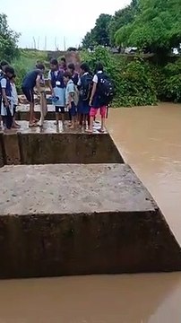 जान जोखिम में डालकर नाला पार कर रहे छात्र