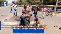 Three protesters take shower in Kisumu street during demos