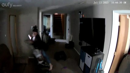 Une femme trébuche sur une valise et un aspirateur