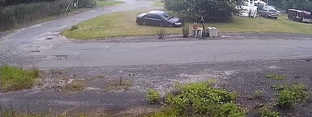 Une voiture roule sur la pelouse pour frapper une boîte aux lettres en ciment