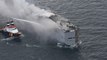 Fire on ship carrying 3,000 cars burns out of control and kills crew member