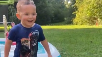Boy walking backwards, saying goodbye, unexpectedly falls in the swimming pool