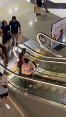 Une personne distraite ne réalise pas que l'escalator est arrêté
