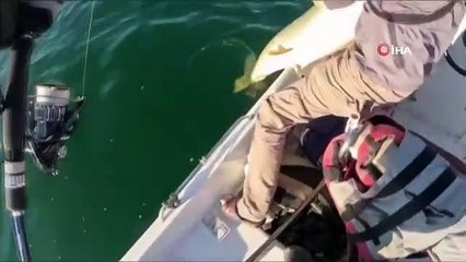 Il a attrapé des poissons jusqu'à sa longueur avec une canne à pêche.