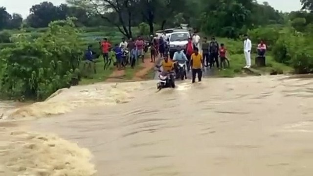 पुलिया के ऊपर से बह रहा था पानी, पार करते समय बाइक समेत बहा युवक- देखें वीडियो