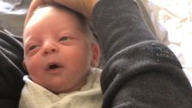 Sleepy baby passes the PUREST smile in the world when mom caresses his face