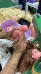 Le fabricant de poupées coud les cheveux