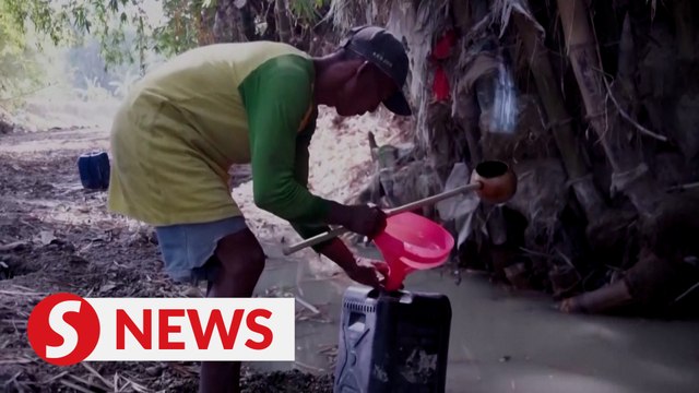 Indonesian villagers dig up dry river bed in drought