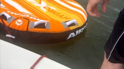 Man takes an unexpected splash as prankish friends pull away the tube at the last moment