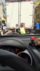 Hondureño arriesga su vida al ir colgado de un camión repartidor