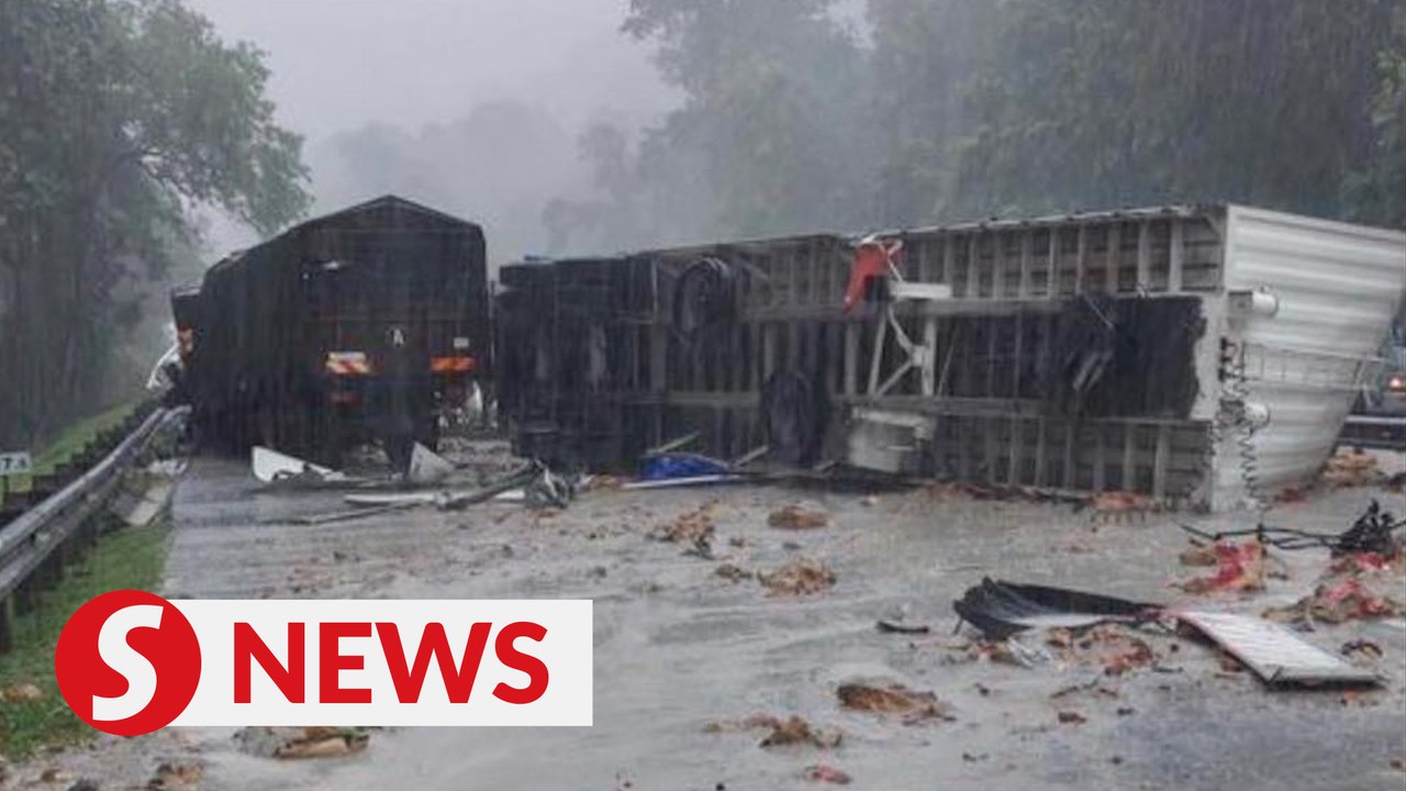 Two killed after trailer crashes through divide...