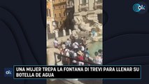 Una mujer trepa la Fontana di Trevi para llenar su botella de agua