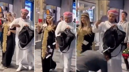 Araplara özgü kıyafet giyen bir kadın ve erkek para dağıttı