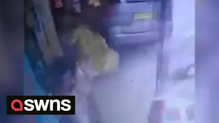 Woman has lucky escape after car mounted kerb and smashed into shop