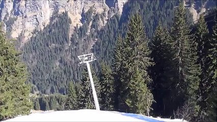 Il skie sur un câble de télésiège en parapente