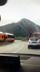 Un train traverse le passage à niveau les barrières relevées