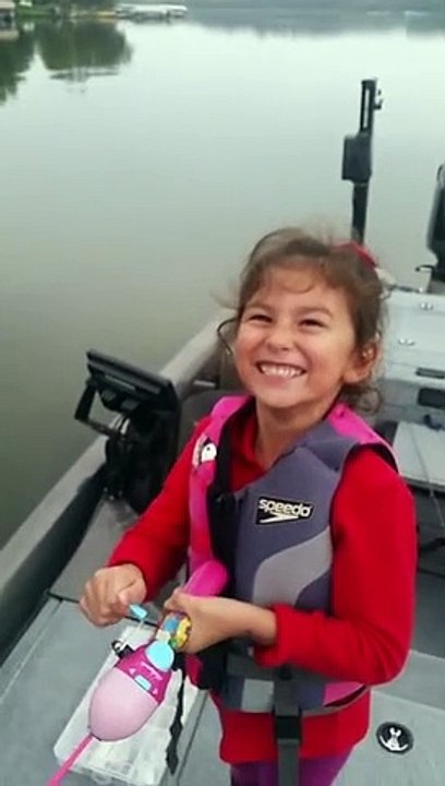 Une petite fille attrape un gros poisson avec sa canne à pêche Barbie