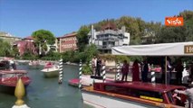 Venezia 80, Brignano e la moglie arrivano al Lido. Il tenero bacio sul molo