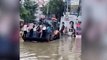Students travel to school by digger after heavy flooding