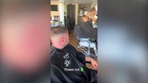 Barber hit by powercut honours appointments by cutting customers' hair in the street
