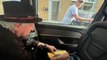 Rolling Stones’ Keith Richards jokes with cyclist as he signs autograph in back of taxi at traffic lights
