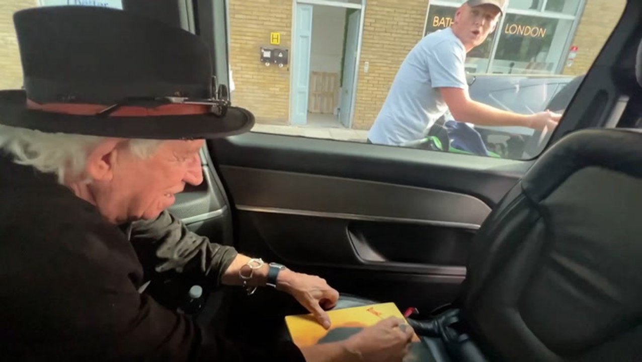 Rolling Stones’ Keith Richards jokes with cyclist as he signs autograph ...