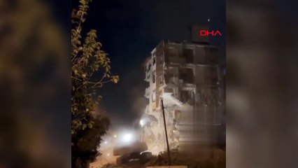 Depremde hasarlı bina yıkılırken iş makinesi üzerine çöktü