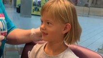 Little girl bravely sits through the ear piercing without any extreme reaction