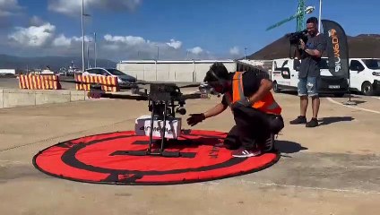 Un trabajador de la empresa ajustando la carga al dron