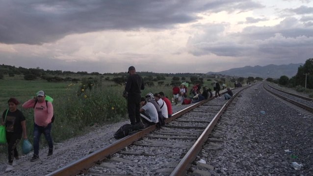 Migrants line tracks of Mexican railway as operator halts trains due to injuries