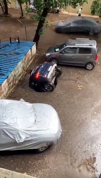 Une voiture garée se fait engloutir par un trou