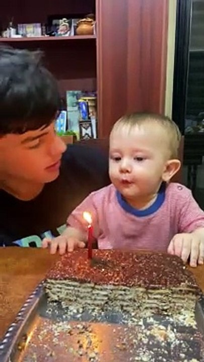 Un frère est distrait pendant l'extinction d'une bougie d'anniversaire