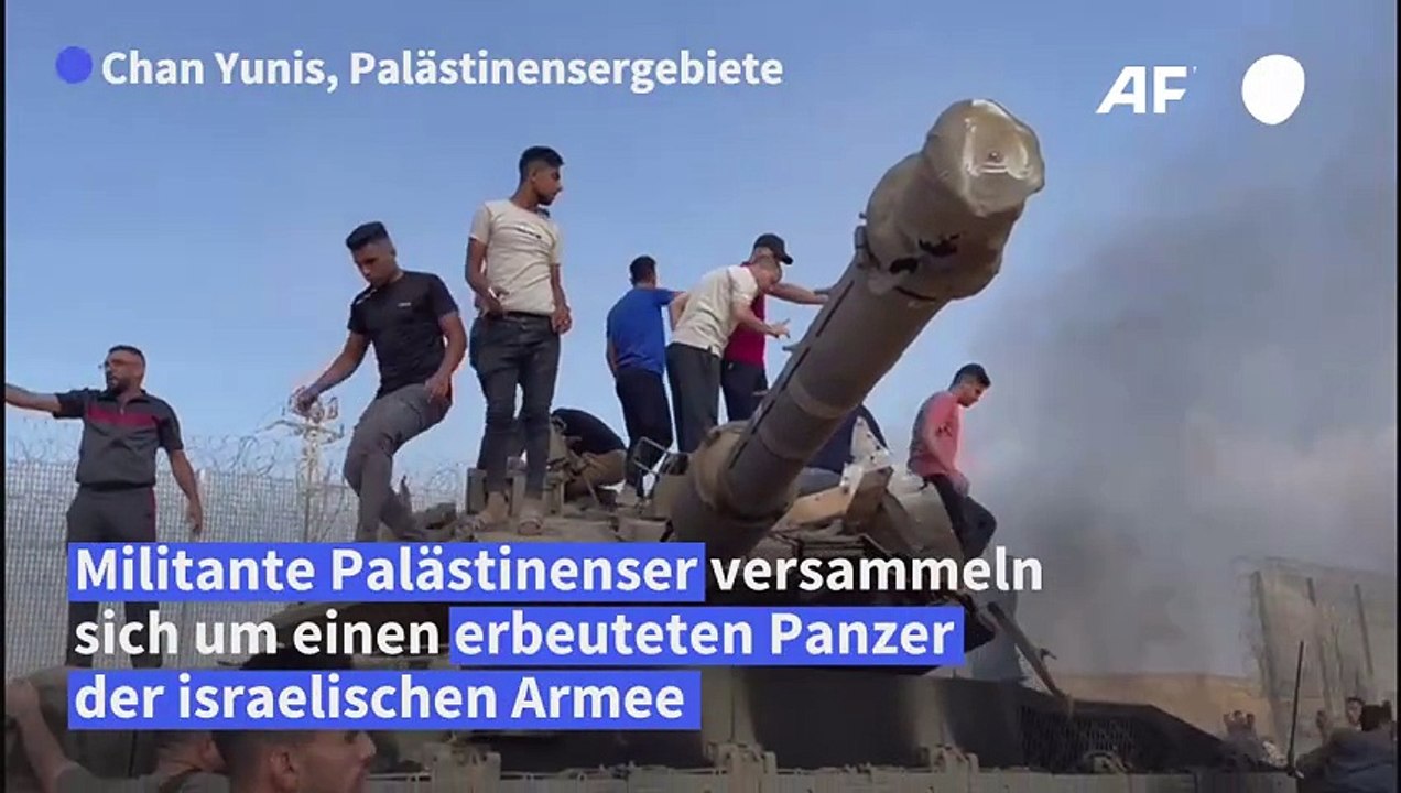 Militante Palästinenser jubeln an erbeutetem israelischen Panzer
