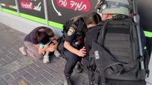 Dos policías israelíes cubren a un niño mientras suenan las sirenas de alerta