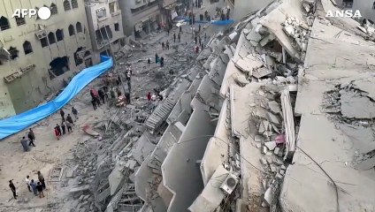 Gaza, vigili del fuoco al lavoro tra le macerie di un palazzo