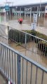 Un cycliste tente de traverser un parking inondé