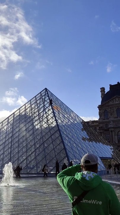 Des militants du collectif écologiste Dernière Rénovation recouvrent de peinture orange la pyramide du Louvre à Paris - Ils exigent la rénovation thermique des bâtiments - Regardez