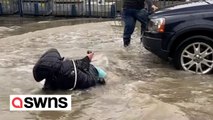 Motorist drives into man in flood water - carrying him on bonnet - before knocking over woman