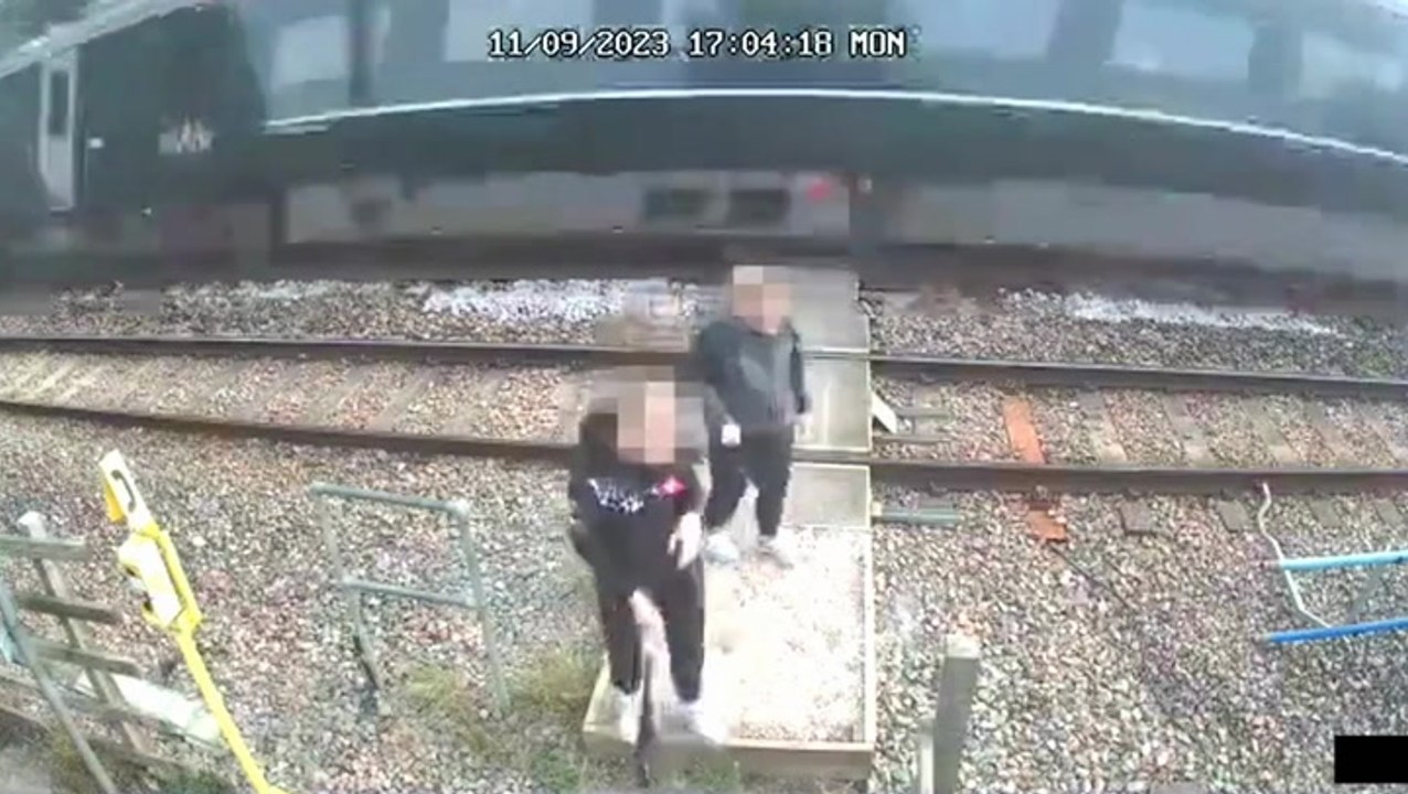 Children push each other as train speeds past on level crossing  in shocking CCTV