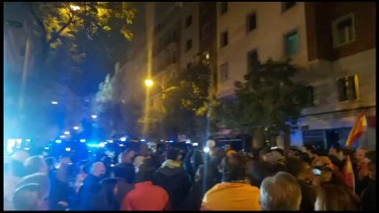 Un hombre con un escudo del Capitán América insta a los manifestantes de Ferraz a no entrar en conflicto con los antidisturbios.