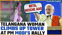 Viral: Woman climbs up a light tower to speak to PM Modi at his rally in Telangana | Watch| Oneindia