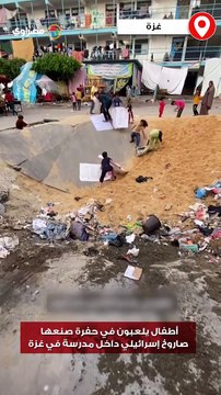 أطفال يلعبون في حفرة صنعها صاروخ إسرائيلي داخل مدرسة في غزة