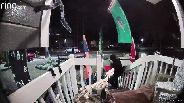 Un adulte semble voler un seau entier de bonbons sur le porche