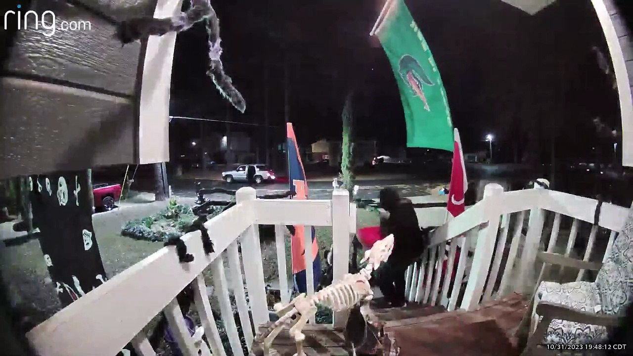 Un adulte semble voler un seau entier de bonbons sur le porche