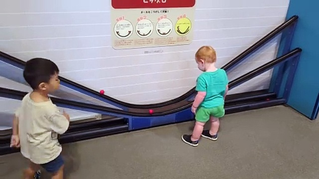 Un garçon a du mal à attraper une balle qui roule