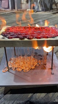 Dripping Molten Glass Over a Wooden Board With Holes