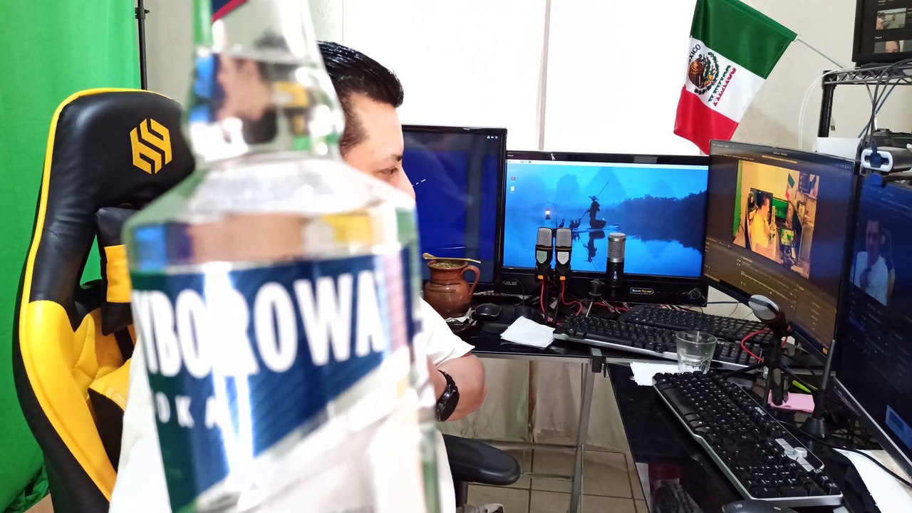 Abriendo una botella de vodka wyborowa y un poco de agua mineral para beber en la oficina mientras trabajo